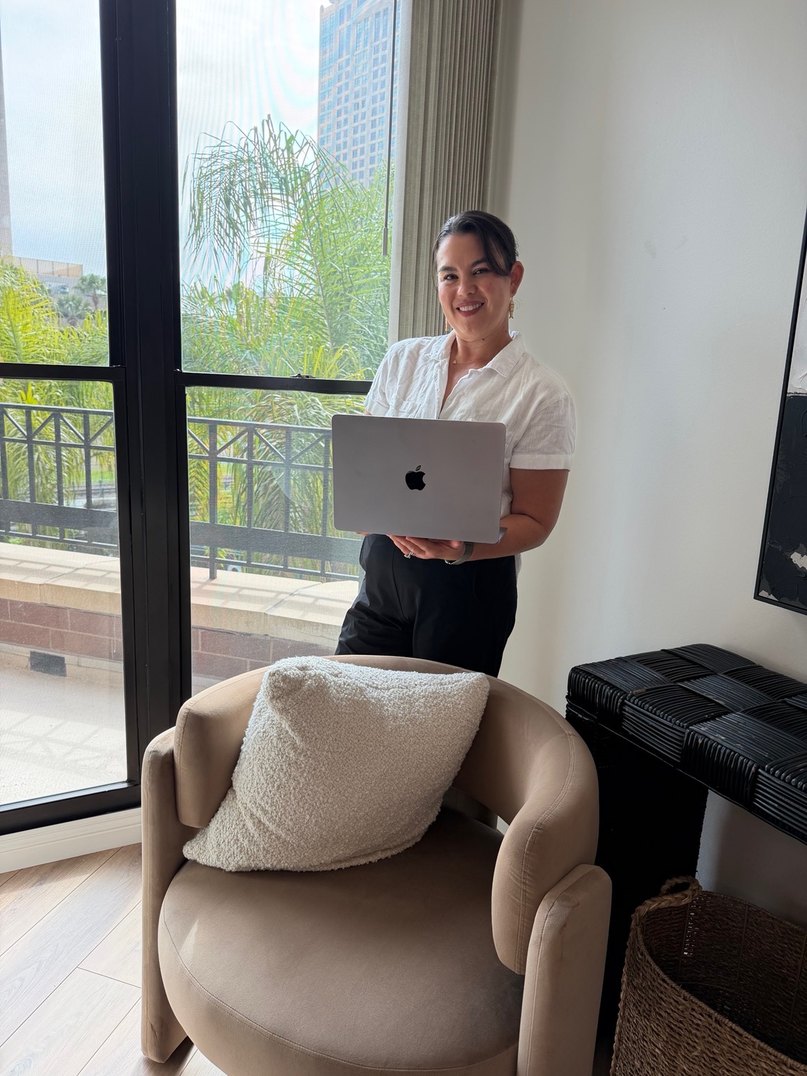 Jen in a bright home office holding her laptop